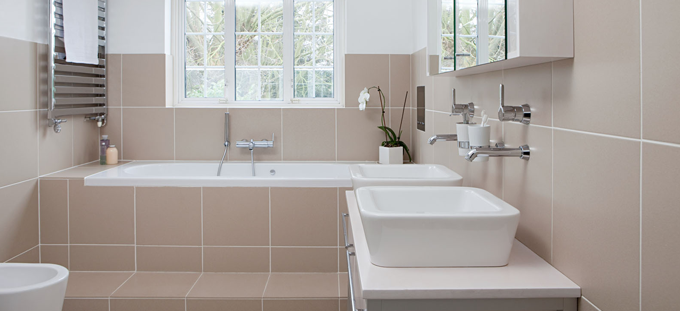 Beige tiled bathroom, chrome towel rail